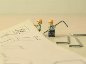 Avoid these mistakes on construction projects. Lego Men looking like they are putting together something from Ikea