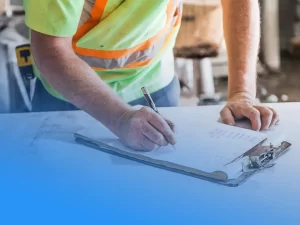 Construction worker writing on a clipboard manually for tool tracking